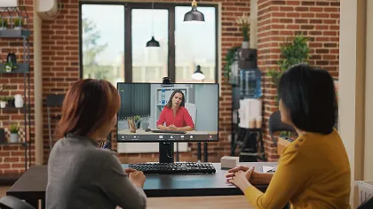 Two women sitting infront of a computer