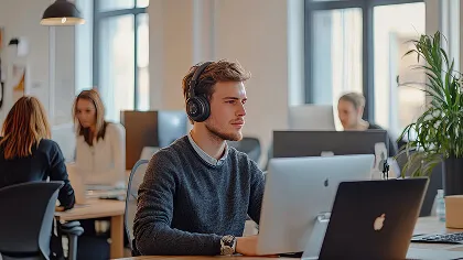 A person wearing headphones sitting at a desk