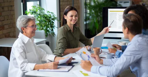 Business professionals in a meeting reviewing documents and charts, representing collaborative GDPR analysis and SAP data compliance planning.